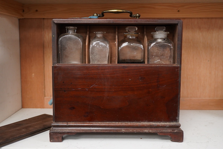 A 19th century mahogany apothecary cabinet, interior with fitting compartments containing twenty-one glass bottles, most with stoppers, five drawers with ivory knobs containing a miniature pestle and water, mixing glasse